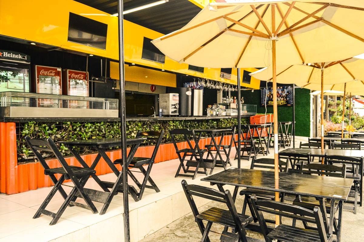 Área de mesas ao ar livre em frente ao bar